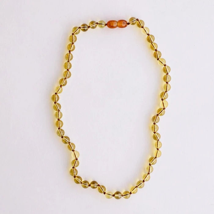 CanyonLeaf Pure Gemstone + Citrine Necklace — a hand-knotted necklace of smooth translucent pale yellow citrine beads with a honey amber screw clasp, laid flat on a white background