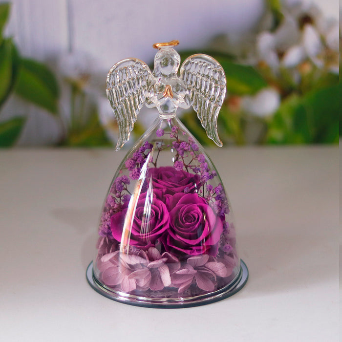 Close-up of the rose arrangement in the angel glass display showing visible form and layered decorative presentation clearly.
