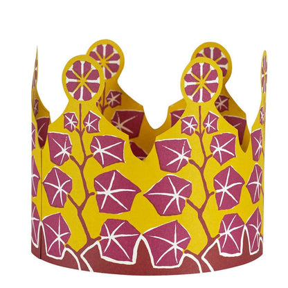 Decorative paper crown with pink floral pattern on a yellow background