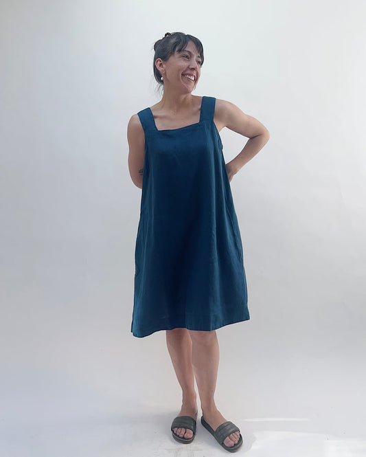 Woman wearing a blue dress standing against a white background