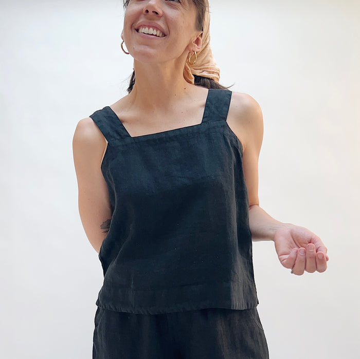 Woman wearing a black sleeveless top against a white background