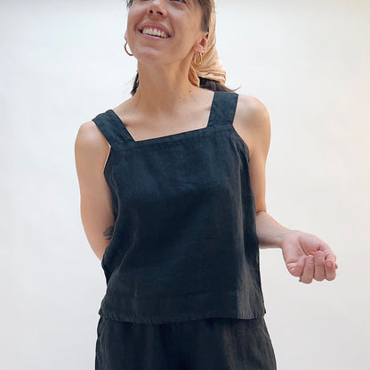 Woman wearing a black sleeveless top against a white background
