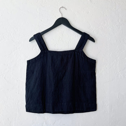 Black tank top on a hanger against a white background