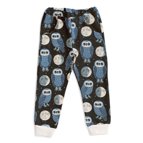 Children's pajama pants with owl and moon pattern on a dark background