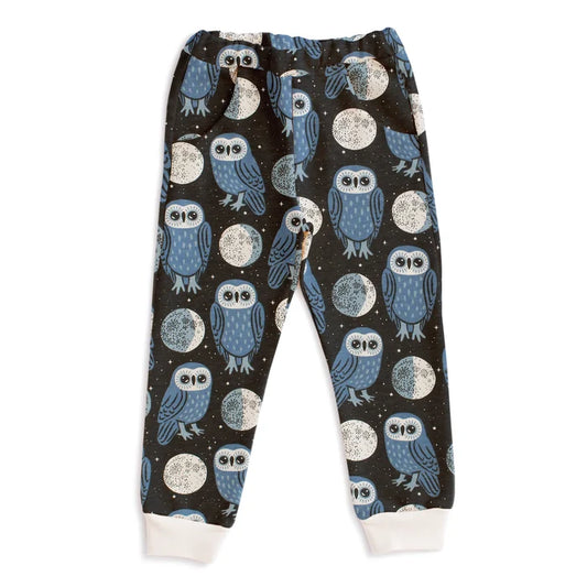 Children's pajama pants with owl and moon pattern on a dark background