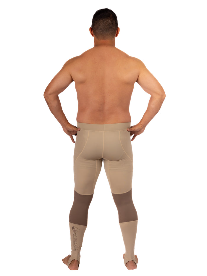 Male model seen from behind wearing Waihana Tan Carvico Lycra rashguard leggings with brown knee reinforcement panels and foot stirrups, displayed against a white studio background.