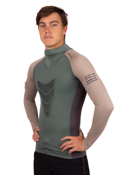 Male model wearing the Waihana Terra Hooded Spearfishing Rashguard in sage green and tan colorblocking with a chest shield panel, mock neck, and Hawaiian flag graphic on the left sleeve, shown from a three-quarter side angle against a white background.