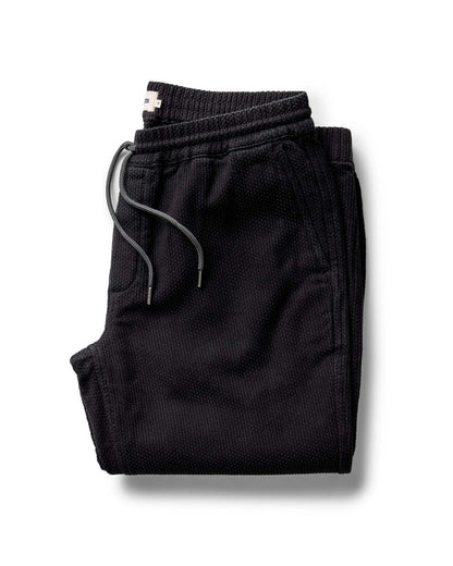 Folded black pants on a white background