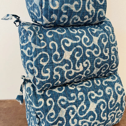 Close-up of the Toiletry Bag in Demeter Blockprint showing the deep indigo quilted cotton with white scrollwork block-print motifs and vertical quilting stitches
