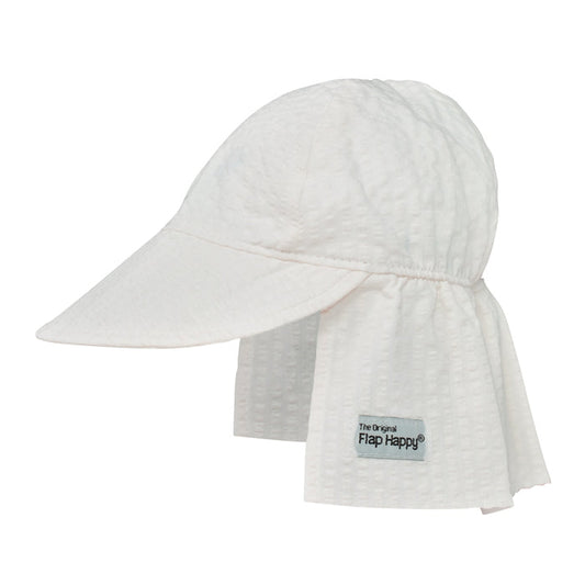 A white sun hat with a large brim and an elastic band, featuring a vanilla stripe pattern and a label that says 'Flap Happy.'