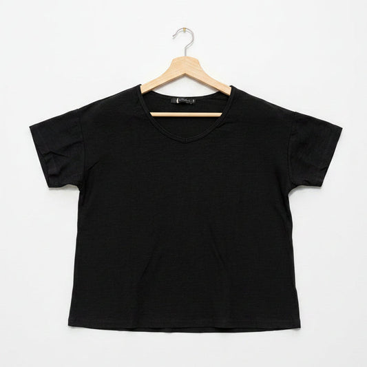 Black t-shirt on a wooden hanger against a white background