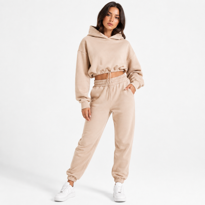 Women's khaki hoodie and jogger set shown on a female model in a full-body studio pose against a clean white background.