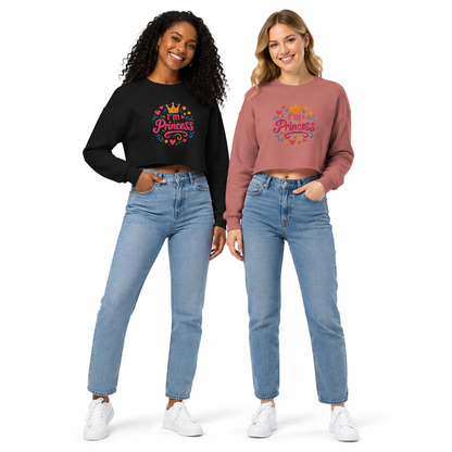 Two women modeling matching graphic sweatshirts and blue jeans against a plain white background. The woman on the left wears a black long-sleeve crop top with a colorful 'My Princess' graphic, and the woman on the right wears a dusty rose long-sleeve crop top with the same graphic.