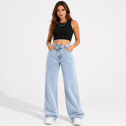Women's high waisted wide leg jeans in light blue wash with crossover waist, shown front-facing with hands in pockets.