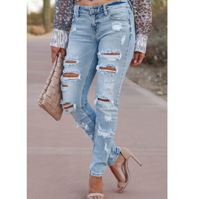 Women's skinny pants – close-up of ripped knees and button detail