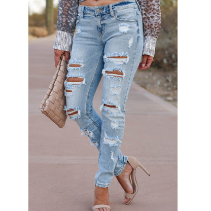Women's skinny pants – close-up of ripped knees and button detail